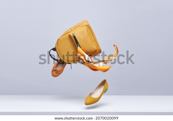 Women's shoes and accessories flying in the air
on a light background. Fashionable women's items. Fashionable and
modern womens handbag and
shoes