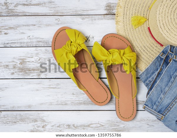 Womens shoes (yellow leather sandals with knotted\
bow). Fashion outfit, spring summer collection. Shopping concept.\
Flat lay, view from\
above