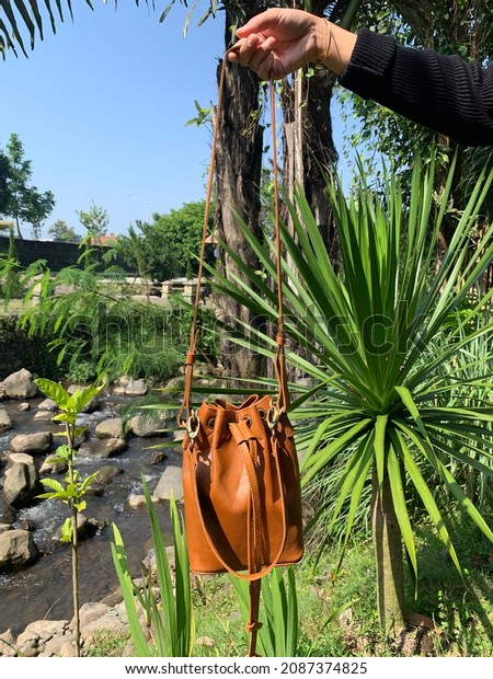 Women\'s sling bag made of genuine cow leather in\
light brown color is perfect for going out for a walk. Good quality\
and durable.