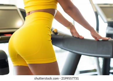 Women's Sportswear In Yellow Color On A Beautiful Slim Model. Sportswoman Posing In The Gym. Close-up Shorts