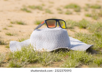 Women's sun hat with sunglasses on the beach.