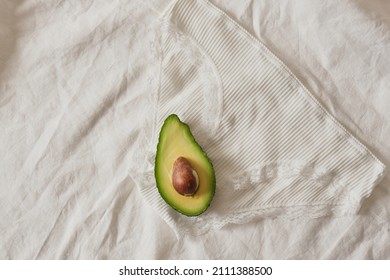 Womens Underwear Briefs And Half Avocado With Seed, Female Health And Sexuality Concept, Underpants On Bed