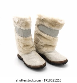 Women's white high fur boots made of muton and genuine leather. Decorated with a suede ribbon . Isolated over white background.
