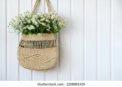 Women's Woven Bag With A Bouquet Of Daisies On A White Wall With Space For Copying. Cottage Core.