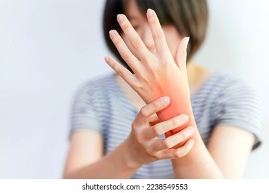 Women's wrist pain from using the hands to work repetitively for a long time or from general diseases of the body such as diabetes, thyroid gland, tumors around the wrist. - Shutterstock ID 2238549553