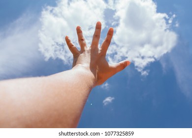 Wonan's hand raised up to the cloudy sky - Powered by Shutterstock