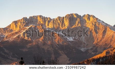 Wonderful aerial landscape from Monte Pora to Presolana mountain range in winter dry season. At sunset the rocks become red, orange and pink. Italian alps. Orobie mountain range