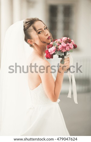 Wonderful bride with a luxurious white dress posing in the old town