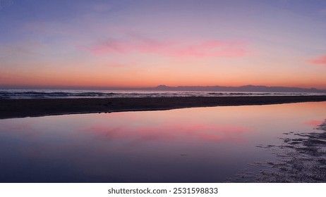 wonderful colorful sunset on a calm sea with a rocky shore. Pink purple sky reflected in water - Powered by Shutterstock