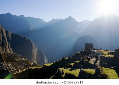 Wonderful effect of sun rays bathing tourists and the citadel of Machu Picchu
