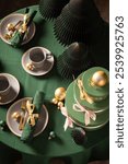 Wonderful green Christmas tableware for two with tableware and presents. Cozy winter composition with decorations.