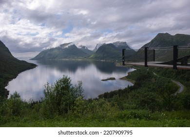 Wonderful landscapes in Norway. Nordland. Beautiful scenery of Senja coastline from the Bergsbotn viewpoint on the Senja scenic route. Mountains and houses in background. Cloudy day. Selective focus