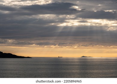 Wonderful Landscapes In Norway. Vestland. Beautiful Scenery Of A Cargo Boat In The Calm Sea At The Sunset In A Cloudy Day With Sunrays Through The Clouds. Yellow Sky. Selective Focus