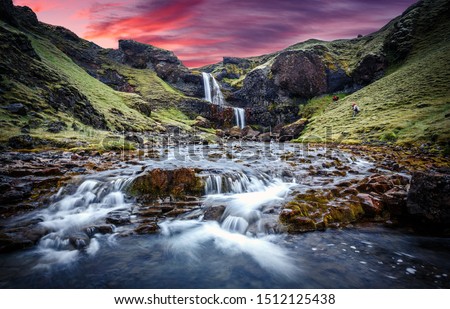 Wonderful nature of Iceland. fresh green grass and icelandic moss near river with waterfall. Typical Icelandic scenery during sunset.  Picture of wild area. Dramatic Scene with colorful sky