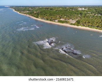 Wonderful Paradise Beach With The Summer Sun Rising In The Middle Of The Atlantic Forest. Tourist Town Arraial D'Ajuda, Brazil, South America. Aerial Drone View.