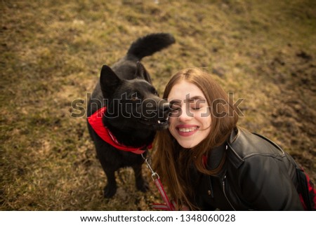 A wonderful portrait of a girl and her dog with colorful eyes. Friends are posing on the shore of the lake