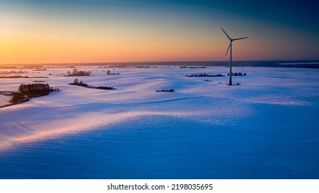 Wonderful Snowy Field And Wind Turbine At Sunrise In Winter, Aerial View