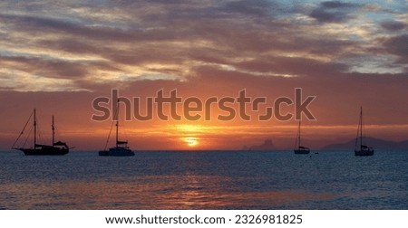 Wonderful sunset close to Ses Illetes beach in Formentera, Balearic Islands, Spain (no visible brand names or logos,only national flags on sailboats).