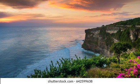 Wonderful twilight sunset seascape of Uluwatu Temple cliff with pavilion and blue sea in Bali, Indonesia. The sky is burst.