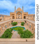 Wonderful view of Agha Bozorg Mosque on blue sky background in Kashan, Iran. The historical mosque and madrasa is a popular tourist attraction of the Middle East.