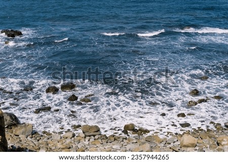 Wonderful view of Eo Gio beach- A tourist attraction in Quy Nhon, Binh Dinh, Vietnam with blue water and high rock cliffs. Ocean waves crashing against the rocky shore. Beach on windy day. 