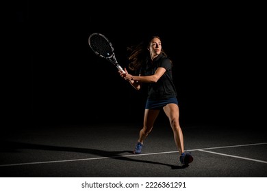 wonderful view on active woman tennis player with racket in black costume playing on outdoor court at evening. Movement, sport, healthy lifestyle concept. - Powered by Shutterstock