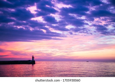 Wonderful view of the sunrise on the sea coast with colored clouds