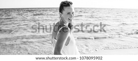 Young blonde woman portrait laughing outdoors sitting in a garden, and looking at camera.