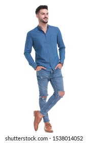 Wondering Casual Man Standing With Both Hands In His Pockets And Looking Away While Wearing Blue Jeans And Shirt On White Studio Background