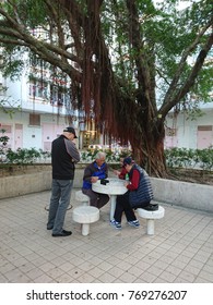 Wong Tai Sin, Hong Kong - 3 Dec 2017: Senior Citizens Play Chess With Their Friends In A Park Inside A Public Housing Estate.