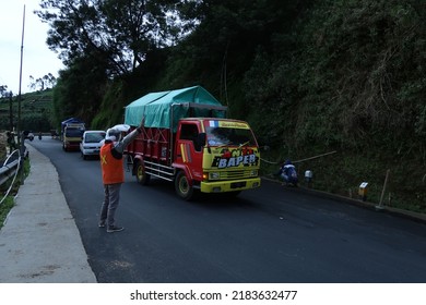 Wonosobo, Indonesia - July 4 2022 : Road Construction On A Slope Road. Man Directing Traffic On The Site