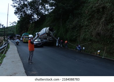 Wonosobo, Indonesia - July 4 2022 : Road Construction On A Slope Road. Man Directing Traffic On The Site