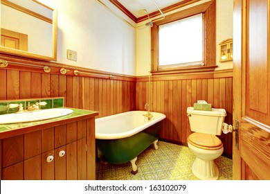 Wood bathroom interior with iron cast bathtub. Old American craftsman style home with lots of wood details.