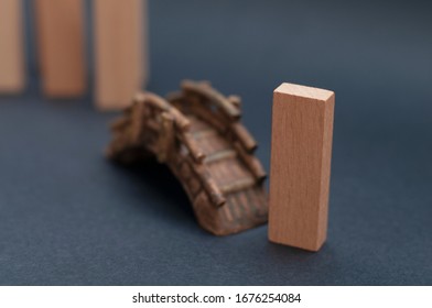 Wood Block Crossing A Toy Bridge On Dark Gray Background. Out Of The Crowd, Leaving The Crowd, Leading, Social Distancing, Self-isolation, Brain Drain And Human Capital Flight Concept.