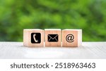 Wood block cube symbol telephone, email, address. Website page contact us or e-mail marketing concept