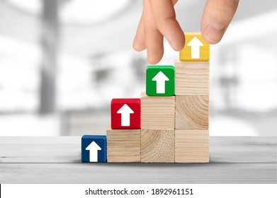 Wood Block Cubic Stacking Step Up With Colored Arrow. Business Concept.