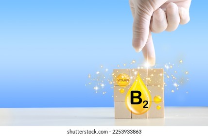 Wood block with Vitamins on it. B2 symbol of the need for vitamins "Vitamin B2 in food" Natural products rich in vitamin B2 - Shutterstock ID 2253933863