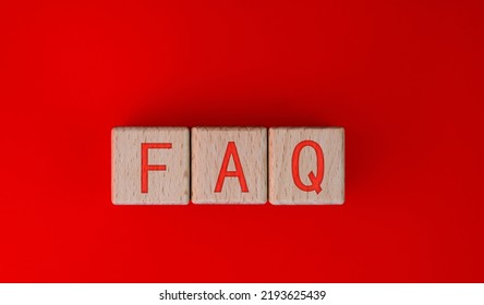 Wood Blocks Spelling FAQ On Red Background.