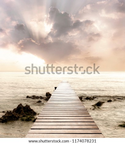 Wood bridge on the sea which has walk way for travel with beautiful sky and sunshine background.