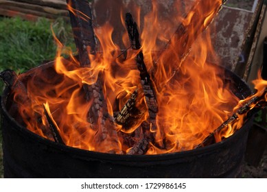 Wood Burning In An Iron Barrel. Fire Close-up. Charred Boards