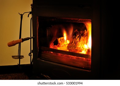 Wood burning stove with fire and poker