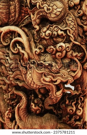 A wood carved dragon, Traditional Chinese style Dragon Abstract with Low Relief Technique. Wooden wall for abstract background patterns, vertical,close up, selective focus.
