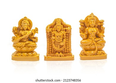 The wood carved idols of Mahalakshmi, Saraswati and Venkateswara Swamy are isolated with white background.