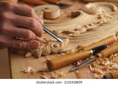 Wood carving. Carpenter's hands use chiesel. Senior wood carving professional during work. Man working with woodcarving instruments - Shutterstock ID 2131418839