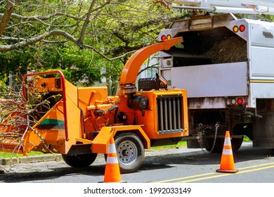 Wood chipper tree branches loaded cut green tree branches in urban neighborhood. - Shutterstock ID 1992033149