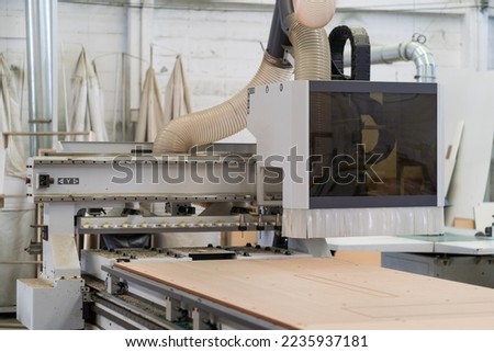 Wood CNC machine at carpentry workshop. Production line of the wooden factory. CNC automatic woodworking machine in manufacturing industry