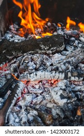 Wood Coals With A Flame In A Black Mongolian Bbq