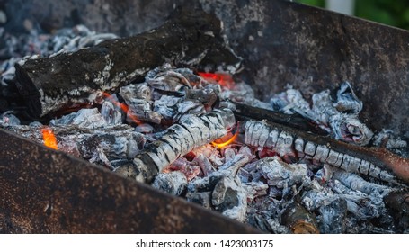 Wood Coals With A Flame In A Black Mongolian Bbq