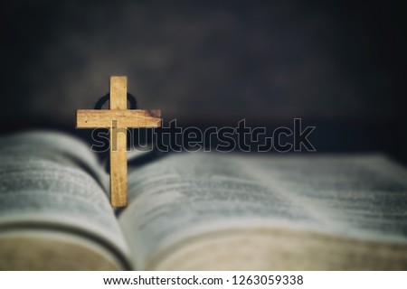 Wood Cross Sign Symbol and Praying to God with a Bible in the Morning Devotion.