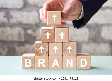 Wood Cube Block With Word BRAND And Arrows On Table. Growth Business And Brand Building For Success Concept.